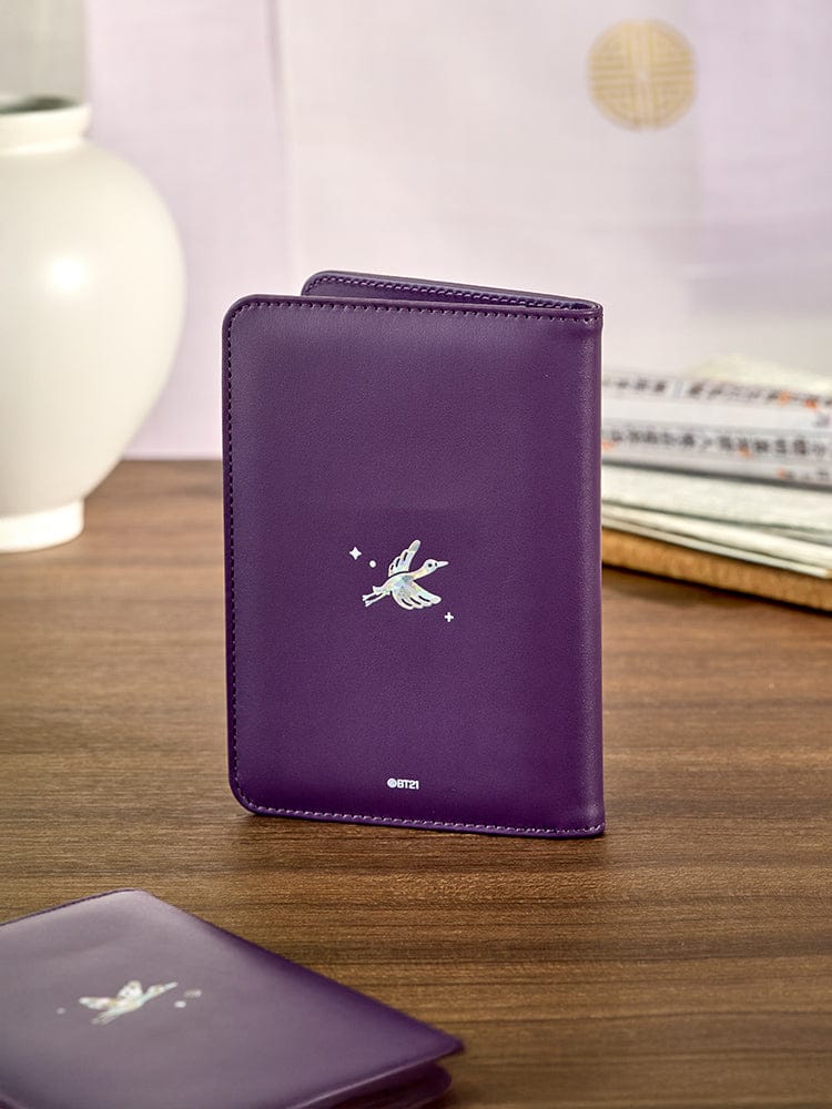 BT21 SHOOKY Premium K Edition Mother-of-pearl Graphic Passport Case, couverture violette avec SHOOKY, sur table de voyage