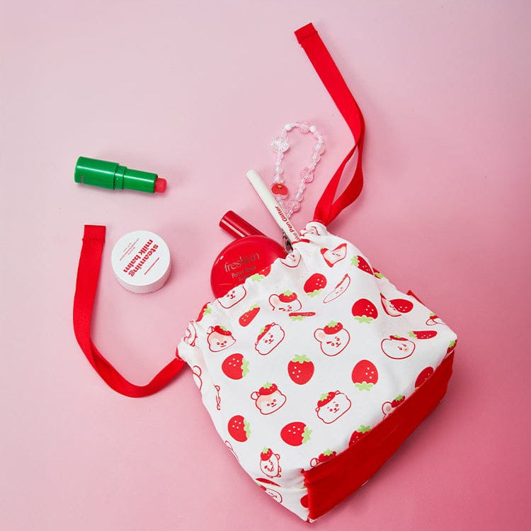 BT21  Strawberry Party String Pouch par la marque BT21, pochon imprimé fraises, fond rose et rubans rouges.