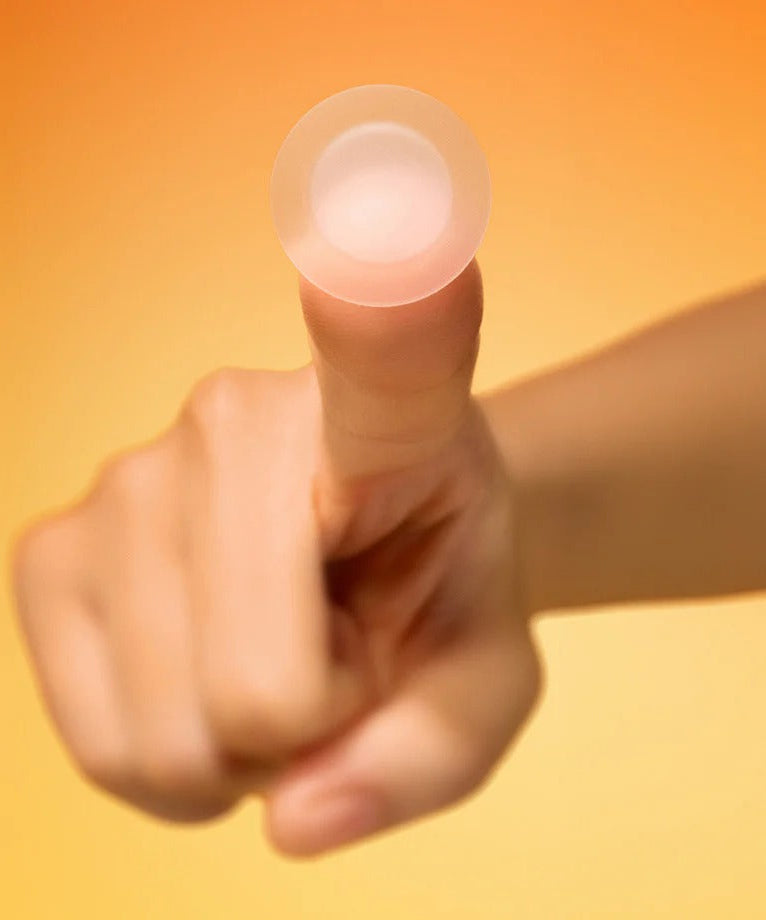 BY WISHTREND Mandelic Acid Spot Clearing Patch 39 Patches, main tenant un patch sur fond orange ensoleillé.