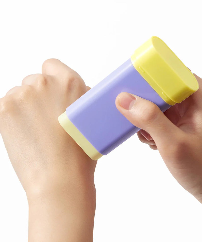 BY WISHTREND Pore Smoothing Bakuchoil Sun Stick 18g, stick solaire tenu en main sur fond clair, marque BY WISHTREND