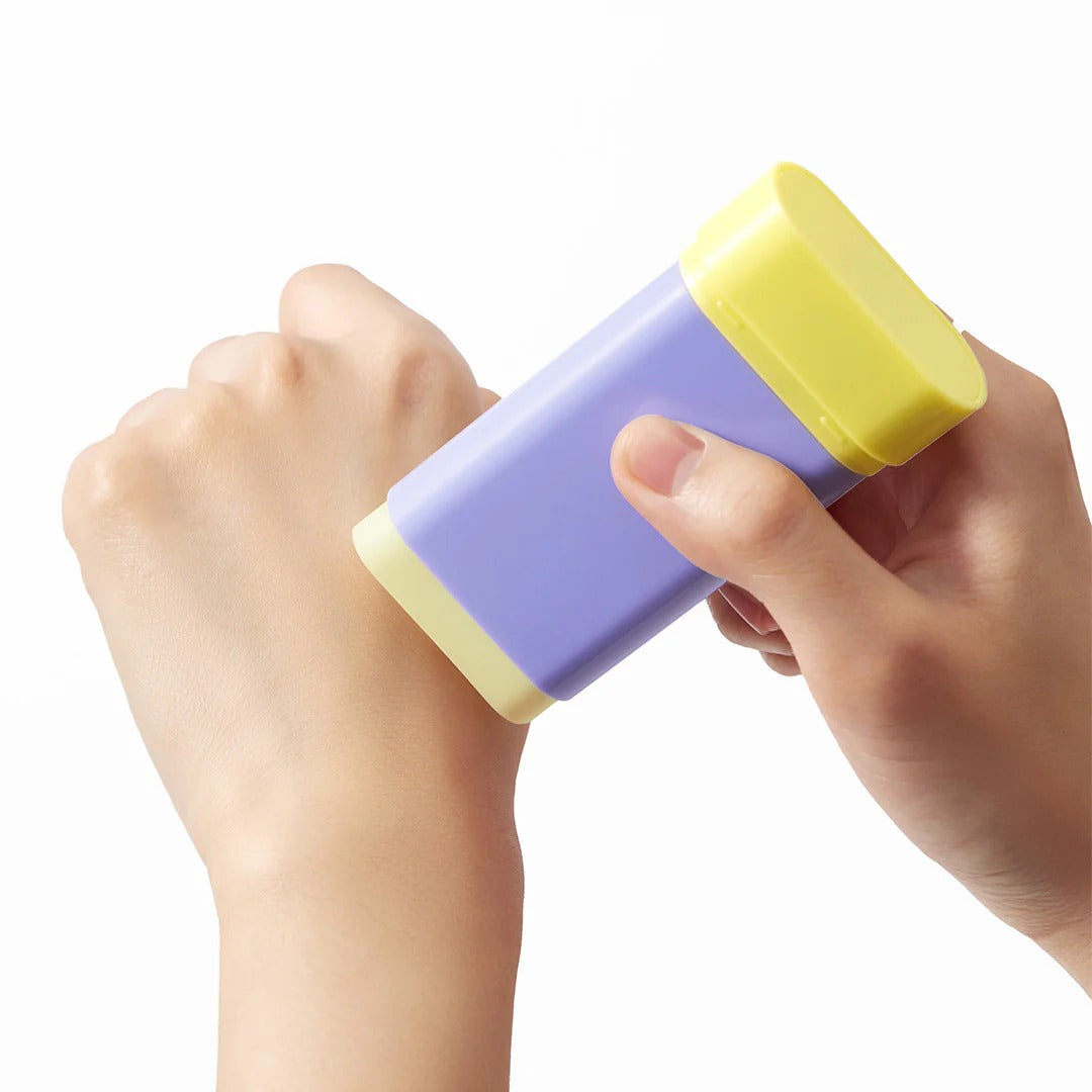 BY WISHTREND Pore Smoothing Bakuchoil Sun Stick 18g, stick solaire tenu en main sur fond clair, marque BY WISHTREND