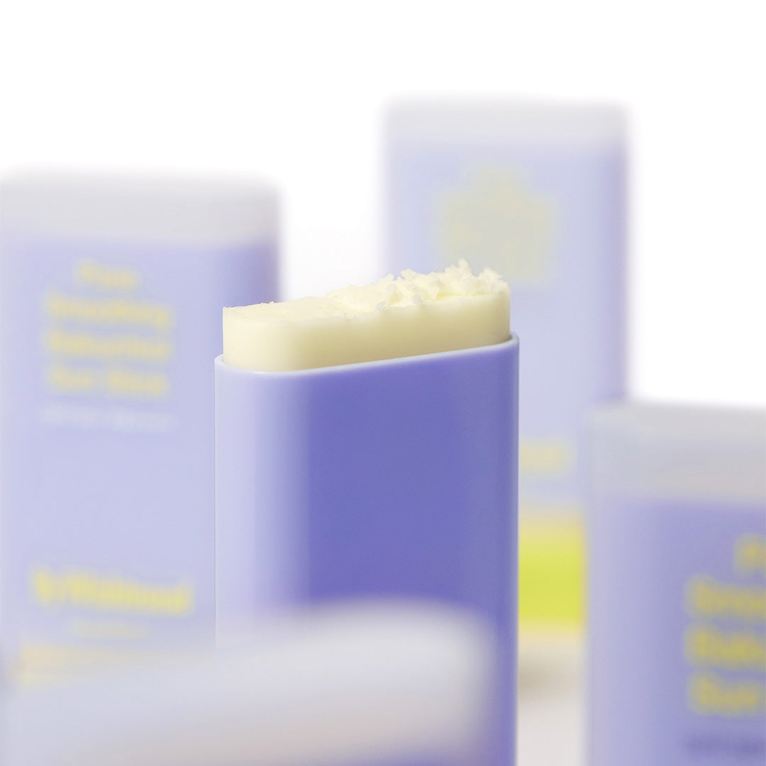BY WISHTREND Pore Smoothing Bakuchoil Sun Stick 18g, stick solaire violet et crème sur fond cosmétique flou.
