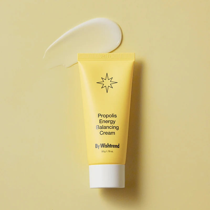 BY WISHTREND Propolis Energy Balancing Cream 50g, tube jaune sur fond beige avec texture de crème, studio beauté