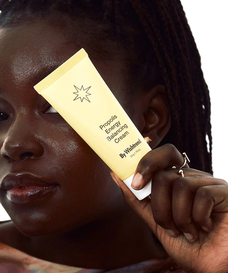 Femme tenant un tube de BY WISHTREND Propolis Energy Balancing Cream 50g pour soins de la peau.