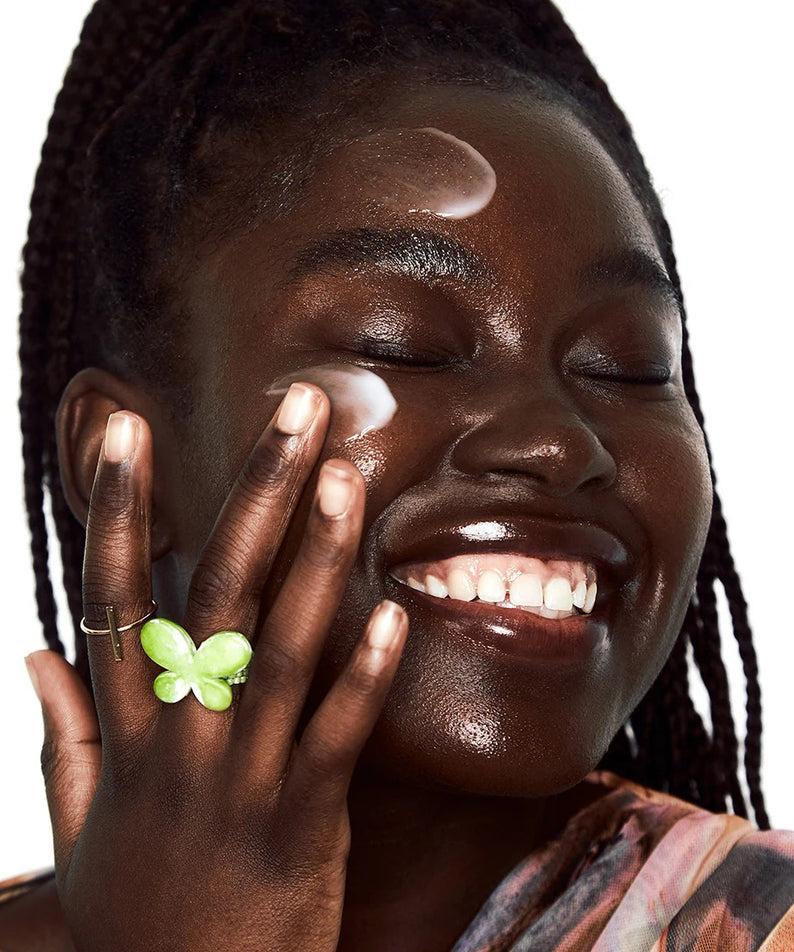 Femme souriante appliquant la crème BY WISHTREND Propolis Energy Balancing Cream 50g sur son visage