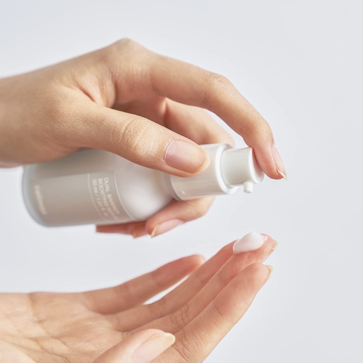CELIMAX Dual Barrier Boosting Serum 30ml : main appliquant le sérum de la marque CELIMAX sur une peau, contexte beauté