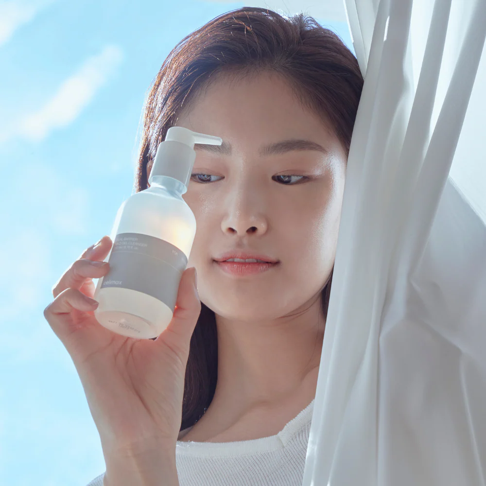 CELIMAX Dual Barrier Mild Gel Cleanser 200ml : femme tenant le flacon blanc, ambiance salle de bain, marque CELIMAX.