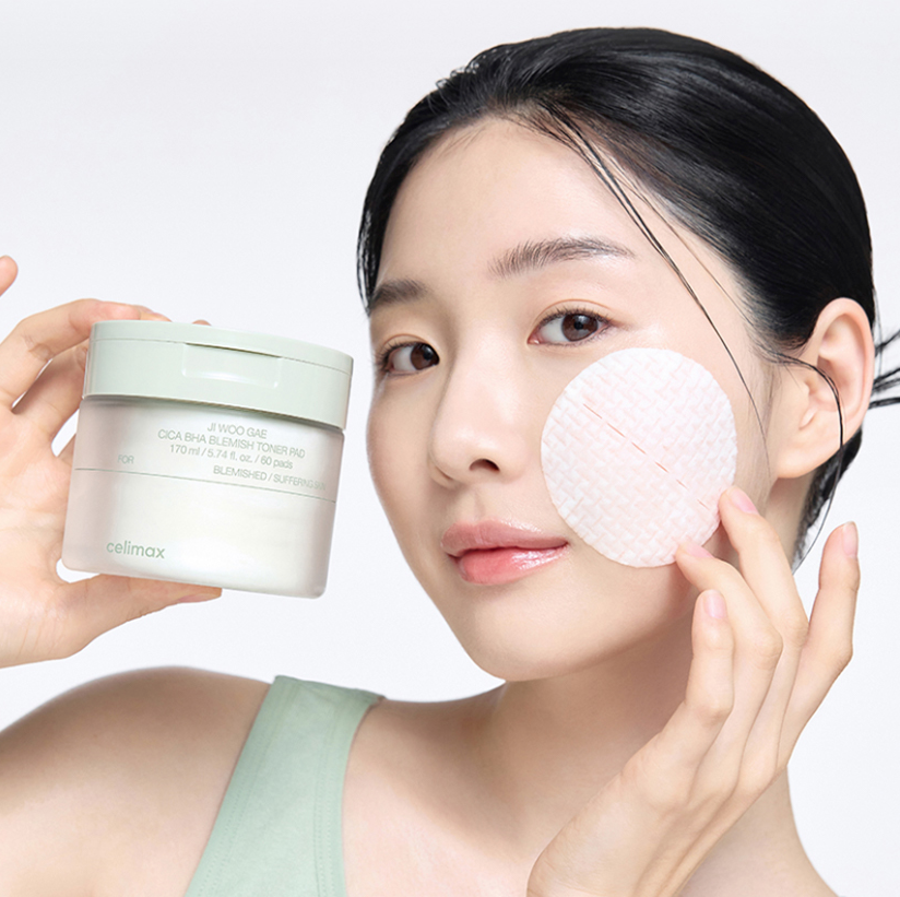 CELIMAX Ji Woo Gae Cica BHA Blemish Toner Pad 60 pads : femme applique un pad, marque CELIMAX, flacon à côté, fond clair.