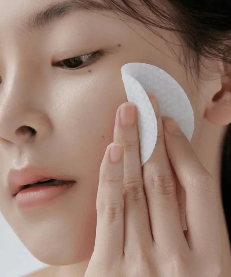 CELIMAX Ji Woo Gae Heartleaf BHA Peeling Pad 60 Pads: femme applique un pad blanc sur la peau du visage, marque CELIMAX