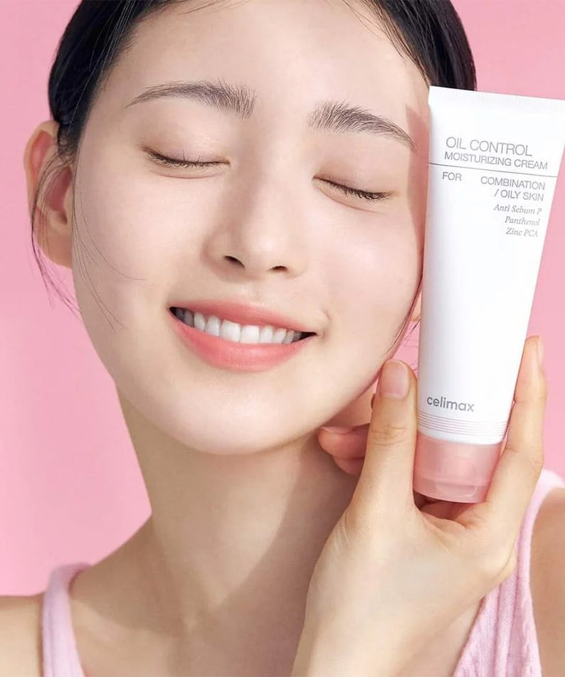 CELIMAX Oil Control Moisturizing Cream 80ml, femme souriante tenant le tube de crème sur fond rose pastel.