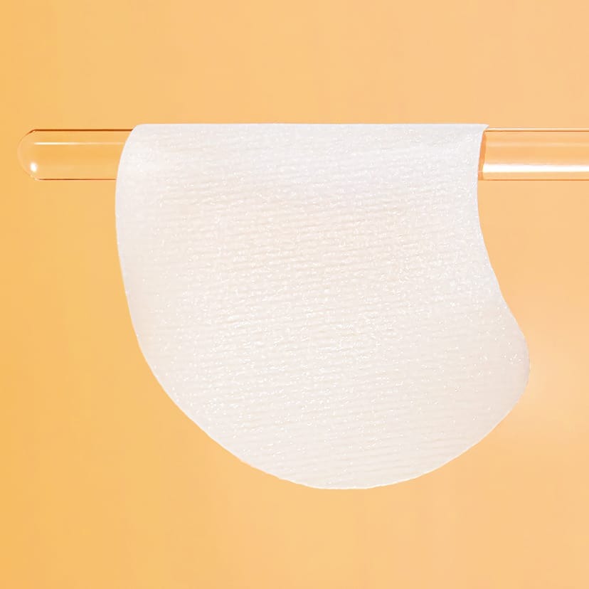 CELIMAX Pore Dark Spot Brightening Pad 40ea : pad blanc appliqué sur fond orange, vue produit de la marque.