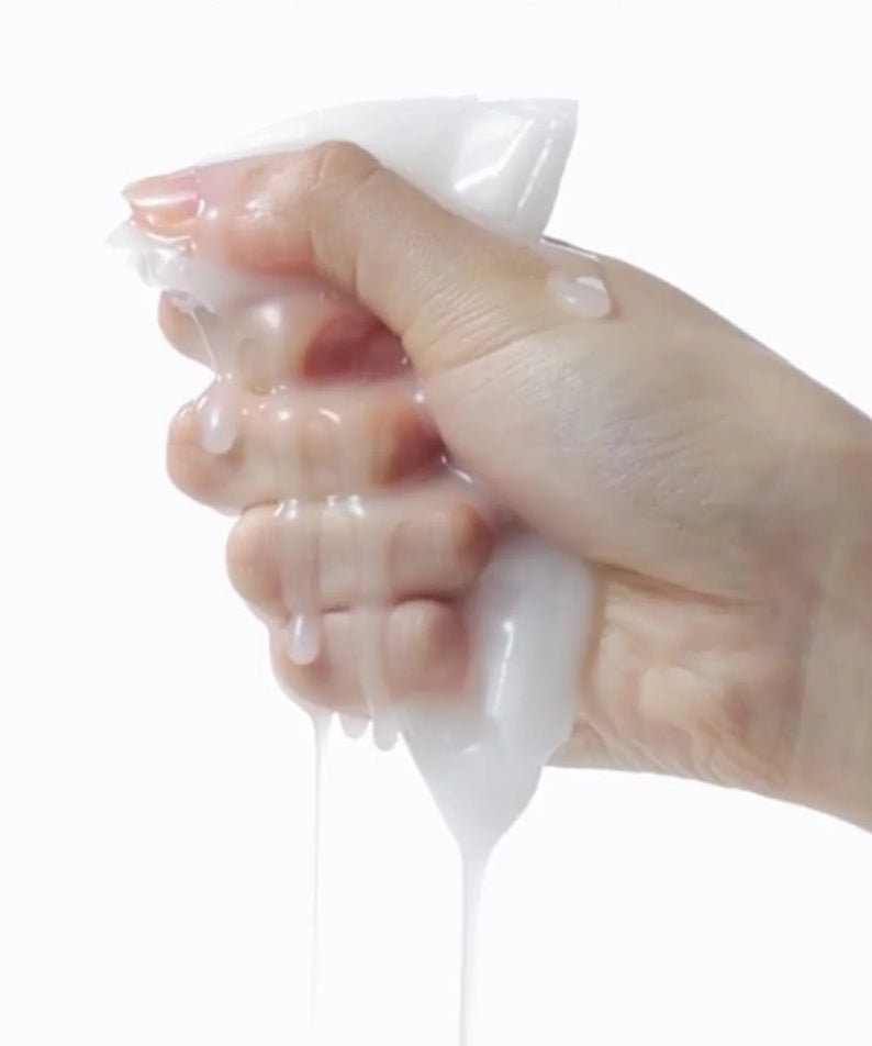 Main tenant une sérum coulant d'un masque CELIMAX Brightening Pore Blemish Serum Mask 10 sheets