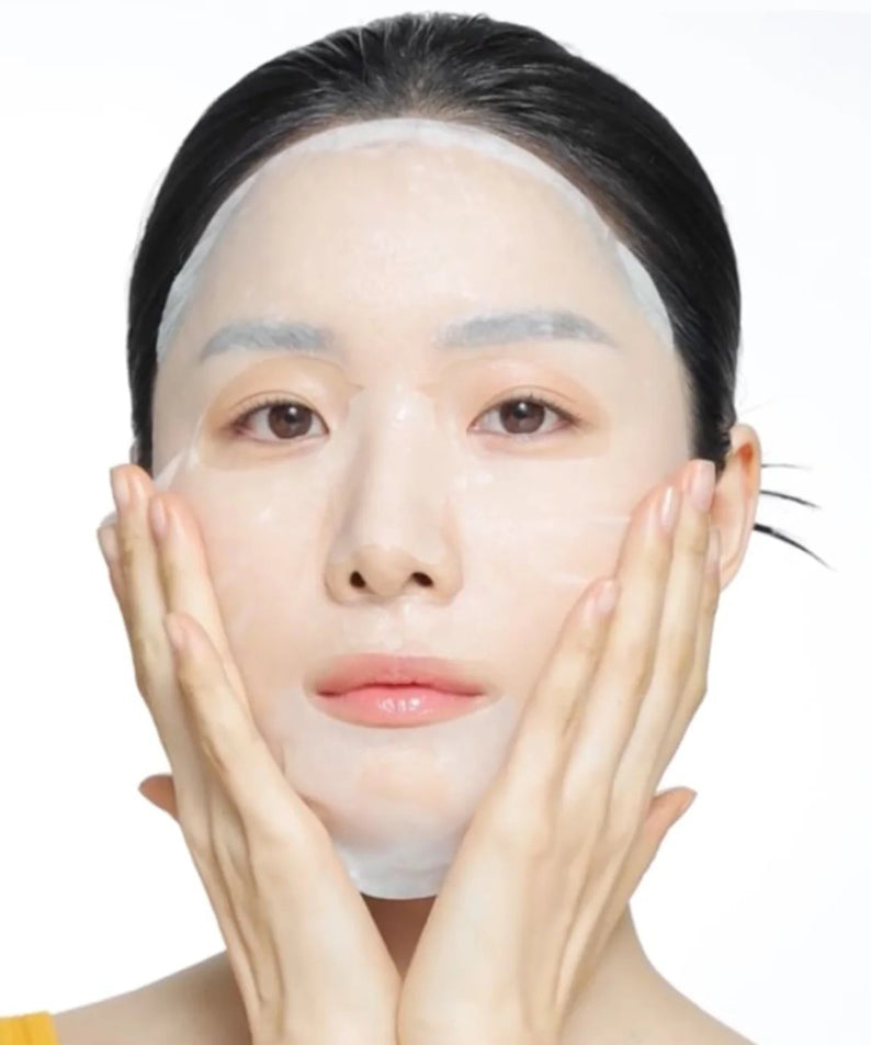 Femme utilisant le CELIMAX Brightening Pore Blemish Serum Mask 10 sheets pour un teint éclatant