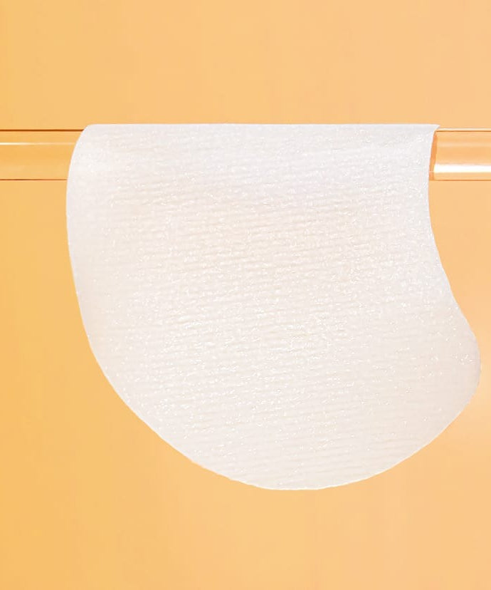 Tampon unique de CELIMAX Pore Dark Spot Brightening Pad 40ea suspendu sur un fond orange vif, soin éclaircissant des pores et des taches sombres.