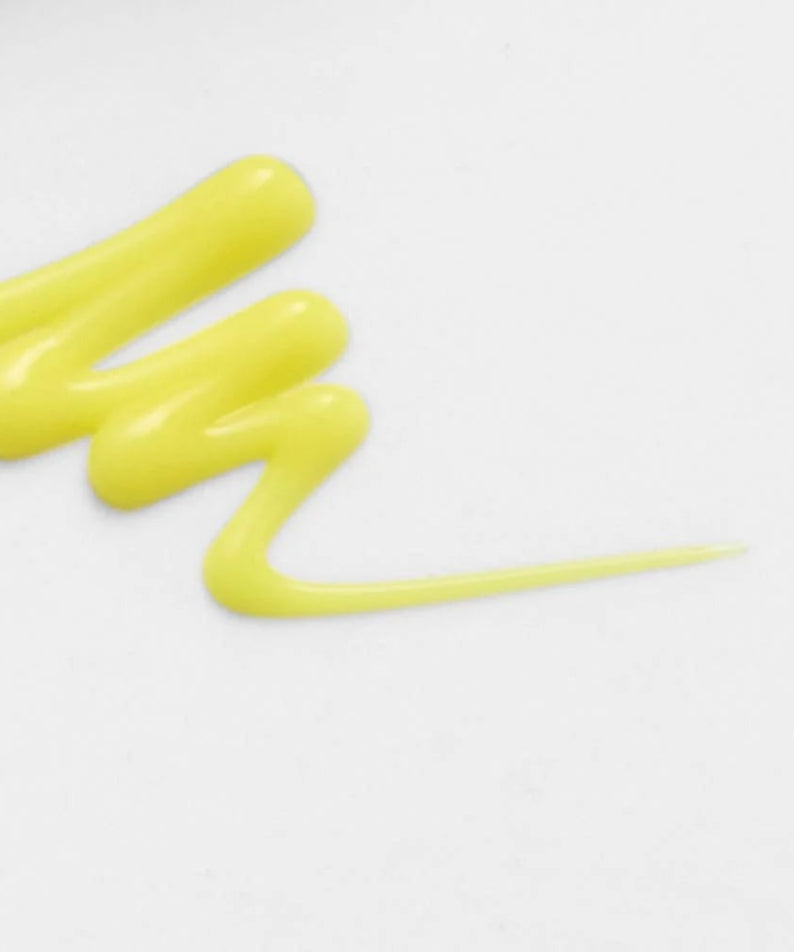 Texture du CELIMAX Retinol Shot Tightening Booster 15ml, crème jaune brillante sur fond blanc, soin raffermissant anti-âge.