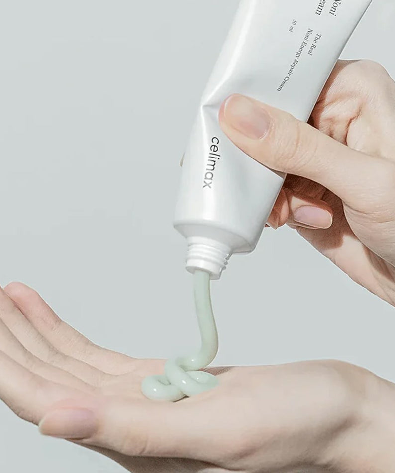 Application du CELIMAX The Real Noni Energy Repair Cream 50ml sur la main pour une peau revitalisée.