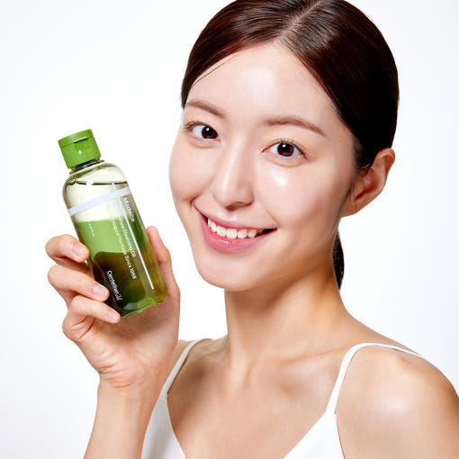 CENTELLIAN 24 Madeca Matcha Cleansing Oil 200ml de la marque Centellian 24, femme tenant le flacon vert sur fond clair