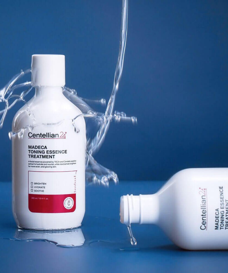 Image du produit CENTELLIAN 24 Madeca Toning Essence Treatment 300ml avec effet éclaboussant sur fond bleu.