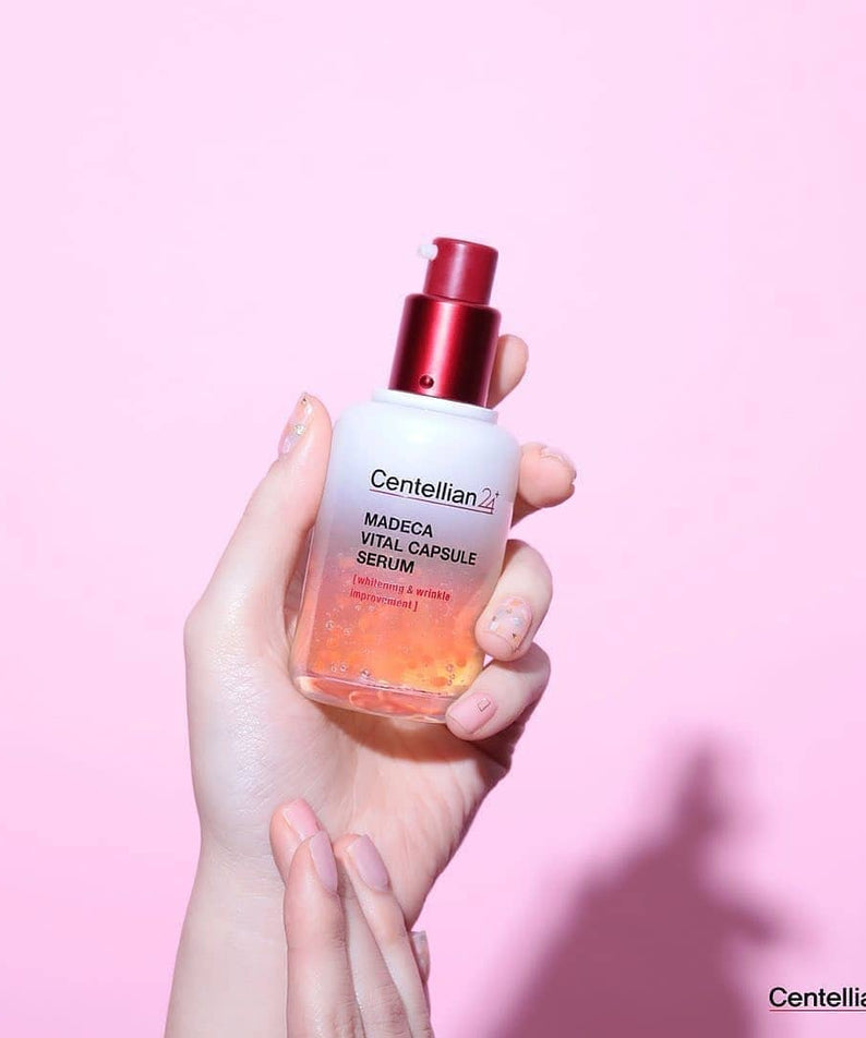 Flacon de CENTELLIAN 24 Madeca Vital Capsule Serum 50ml tenu par une main sur fond rose.