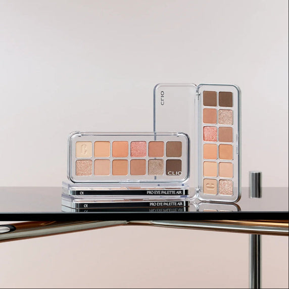 CLIO Pro Eye Palette Air (#01 to #21) de CLIO, palette yeux ouverte avec fards nude et dorés, sur présentoir miroir.