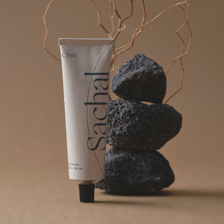 Décris l'image en français: CHWI (CHI) Sachal Hand Cream 50ml, tube de la marque CHWI, main en arrière-plan, déco spa.