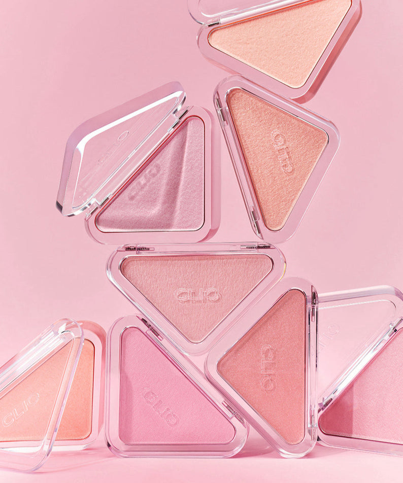 CLIO  Essential Blush Tab, poudres blush roses en étui triangle sur fond rose pastel, packshot de la marque CLIO.