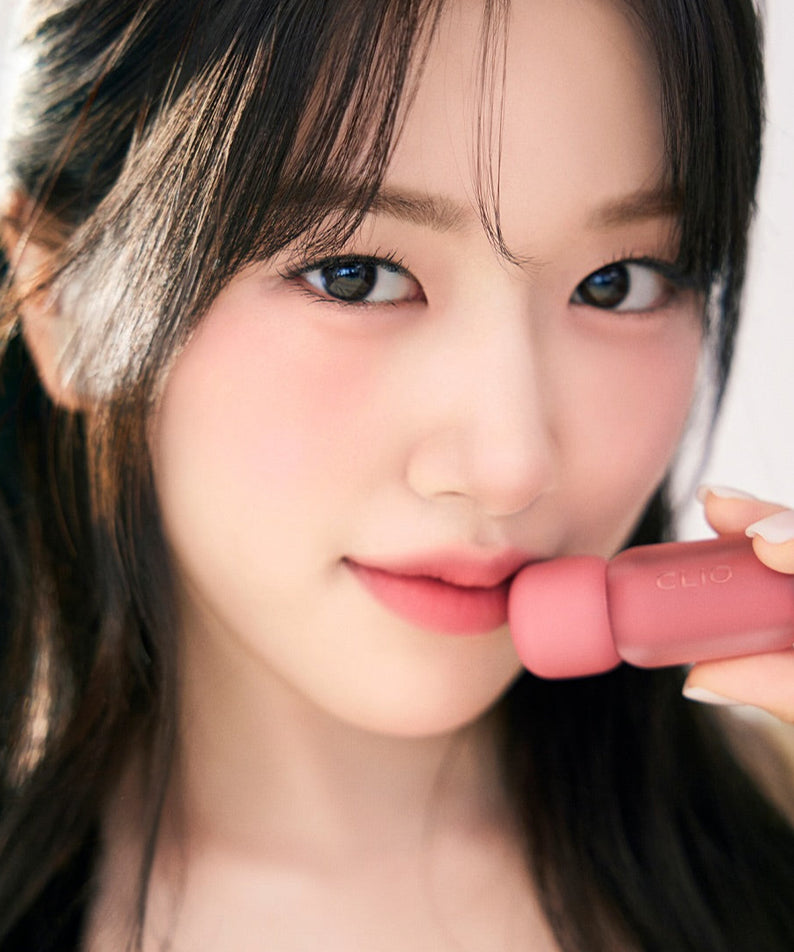 Femme tenant le CLIO Volume Mate Blur Tint/Gloss, maquillage moderne et élégant. Accent sur les lèvres avec produit de beauté innovant.