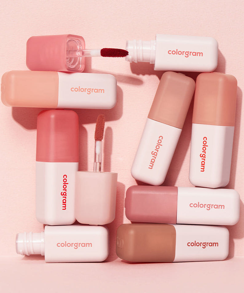 Produits de maquillage COLORGRAM Nude Blur Tint en différents tons doux sur fond rose.
