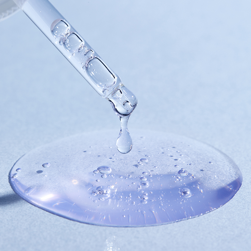 CORALHAZE Vital Ection Soothing Serum 30ml, flacon sérum apaisant sur fond bleu, contexte gouttes d’eau.