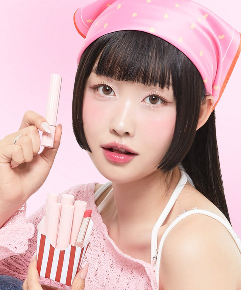Décris l'image en français : CORINGCO Pink Churrons Plumping Glossy Lip, marque CORINGCO, lèvres brillantes, modèle sur fond rose.