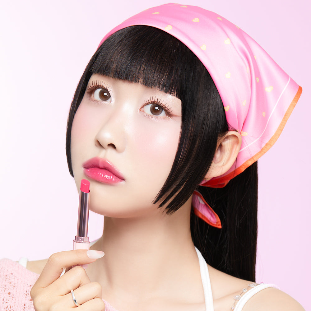CORINGCO Pink Churrons Plumping Glossy Lip, la marque sur un gloss rose luisant, maquillage sur fond rose pastel, portrait