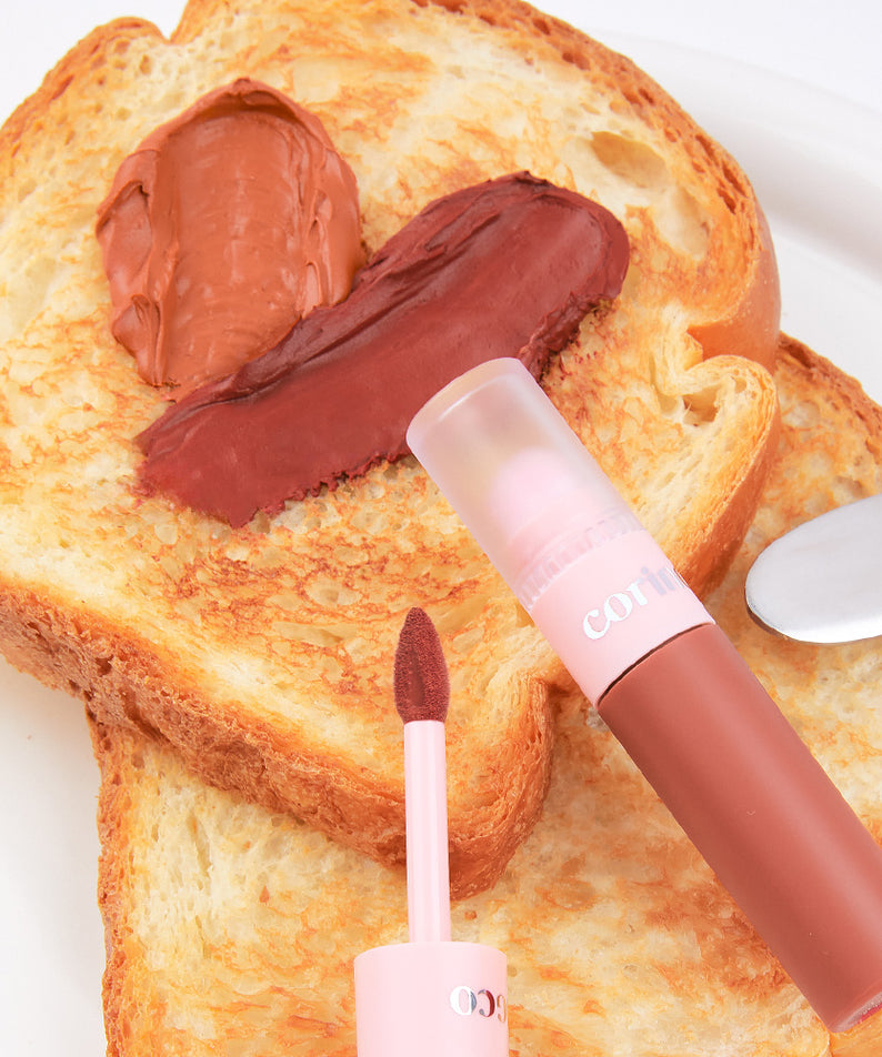 CORINGCO Topping Tip Velvet Lip Tint : tube et applicateur sur pain grillé, crème chocolatée, visuel gourmand, marque CORINGCO.