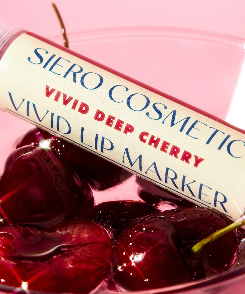 COSIERO Vivid Lip Marker posé sur des cerises, couleur vive pour des lèvres éclatantes.