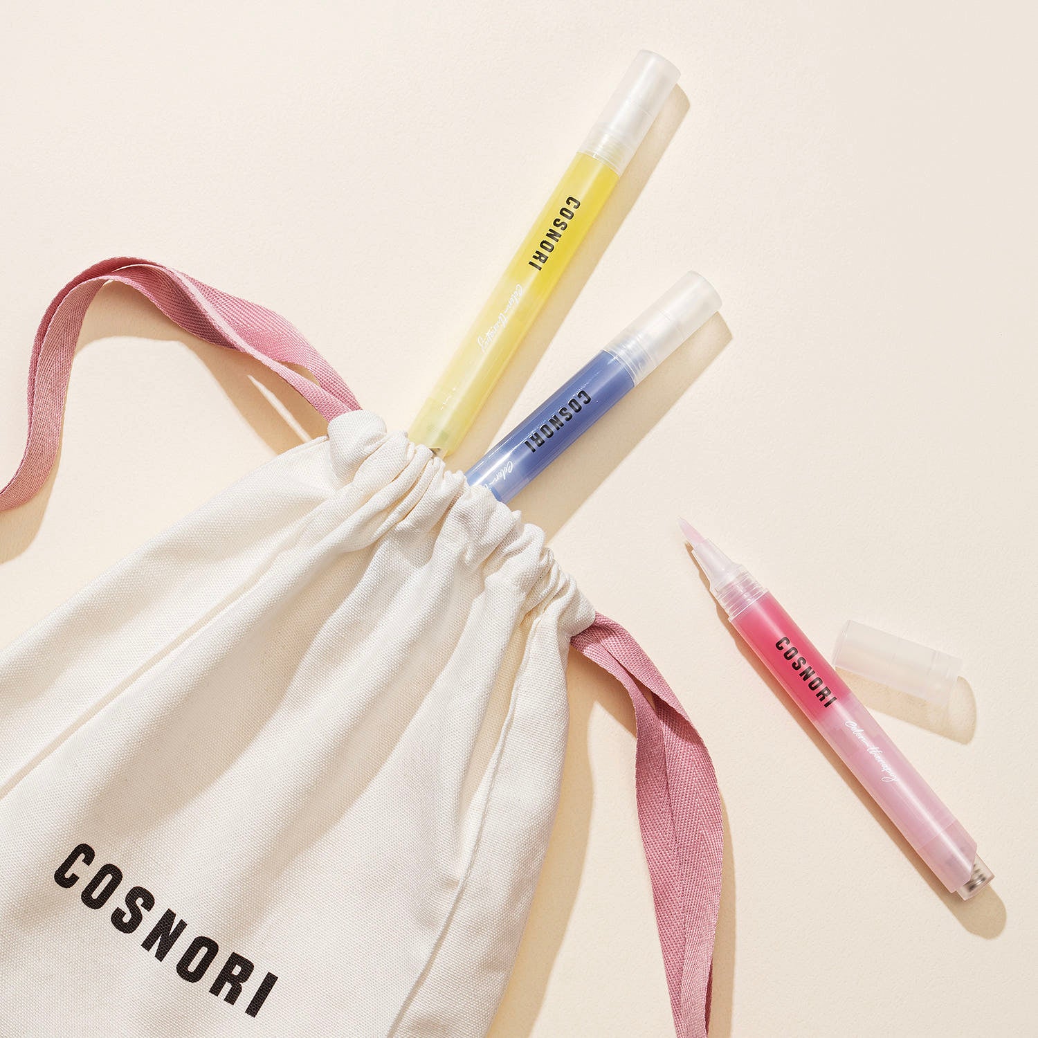 COSNORI Color Therapy Nail Serum 4ml de la marque COSNORI, flacons de sérum sur fond beige avec poches tissus