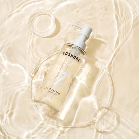 COSNORI Micro Active Cleansing Oil 200ml de la marque COSNORI sur fond crème, flacon et éclaboussures d’eau