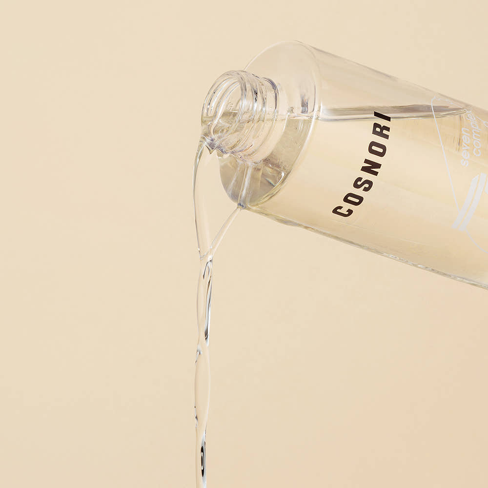 COSNORI Micro Active Cleansing Oil 200ml, flacon transparent déversant de l’huile sur fond beige, gros plan produit marque COSNORI