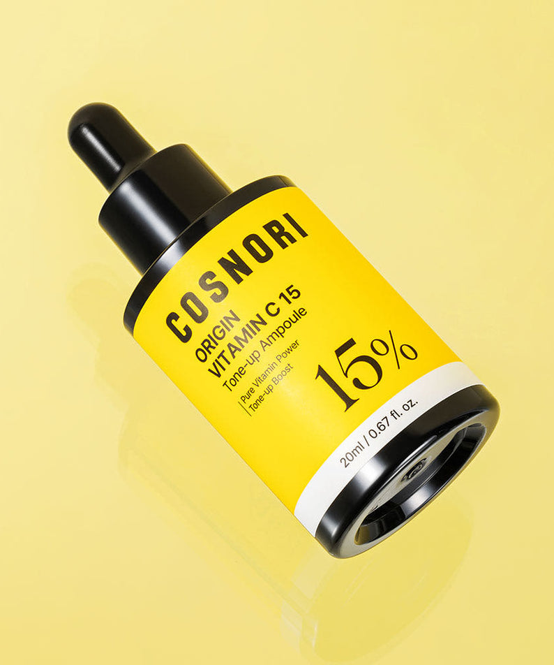 COSNORI Origin Vitamin C 15 Tone-Up Ampoule 20ml, marque COSNORI, flacon jaune sur fond pastel, contexte beauté.