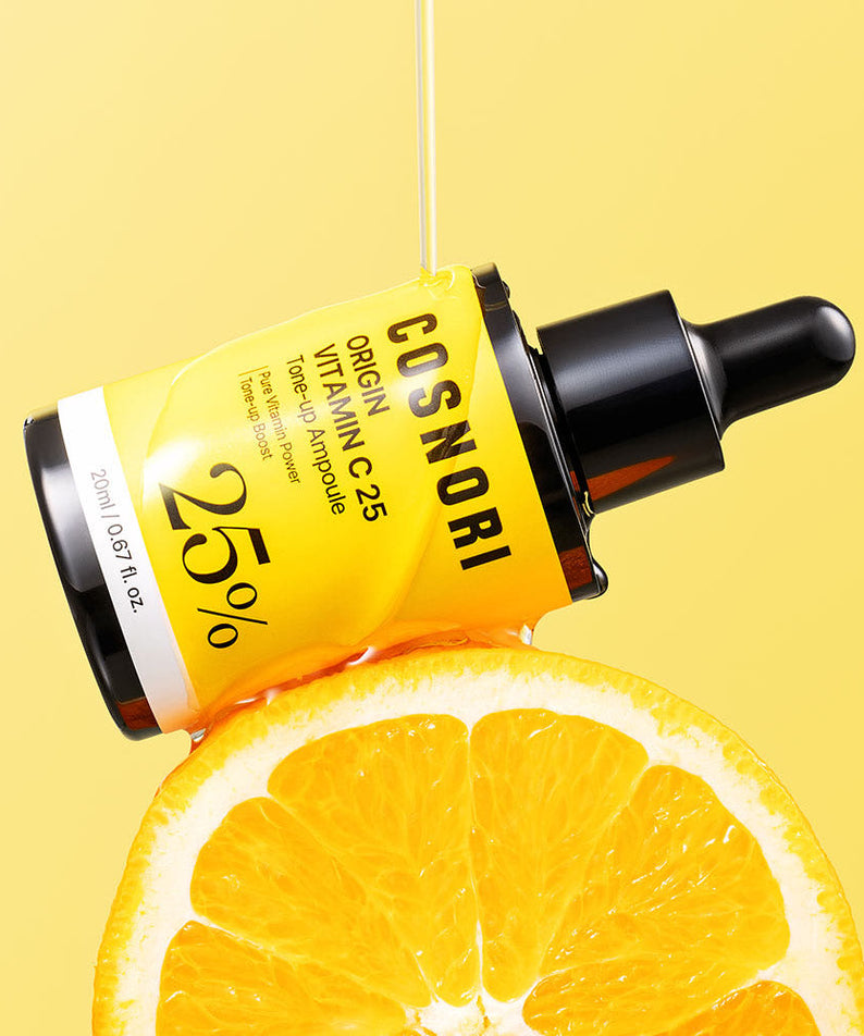 COSNORI Origin Vitamin C 25 Tone-Up Ampoule 20ml, flacon jaune sur fond jaune, avec tranche d’orange et gouttes de sérum