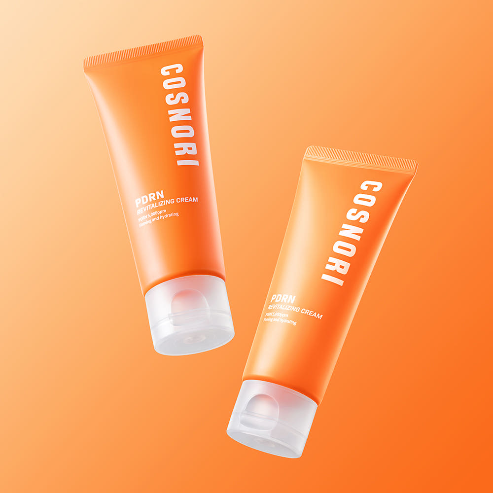 COSNORI PDRN Revitalizing Cream 70ml, tubes orange sur fond uni orange, produit cosmétique COSNORI en studio.
