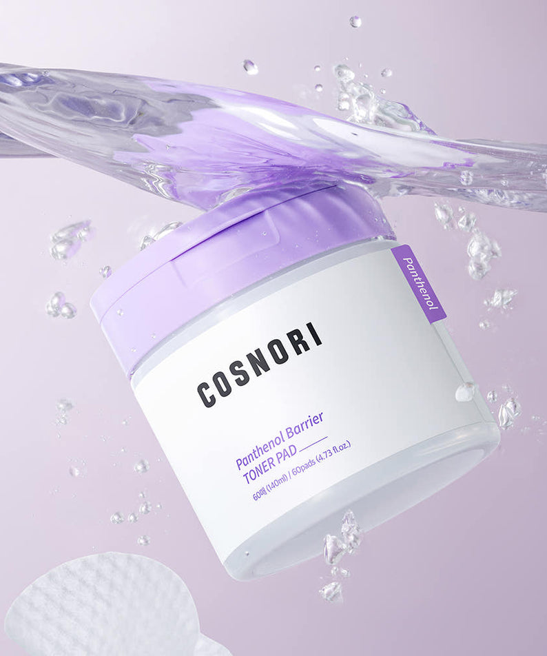 Décris l'image en français : COSNORI Panthenol Barrier Toner Pads 60 Sheets, flacon et pads violets avec éclaboussures d’eau.