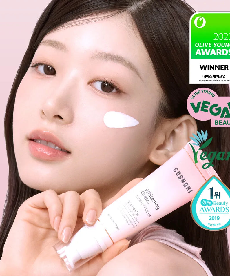 COSNORI Whitening Dress Tone-Up Cream 50ml de la marque COSNORI, sur visage maquillé avec main, fond rose.