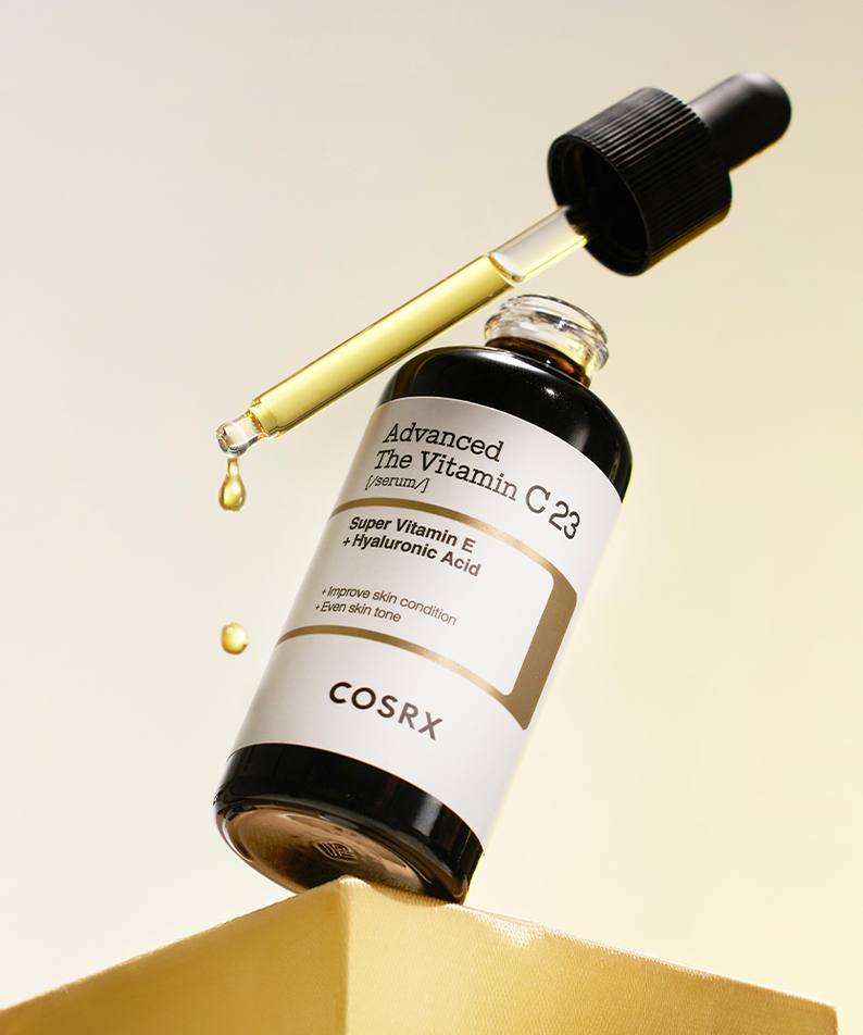 COSRX Advanced The Vitamin C 23 Serum, flacon en verre, marque COSRX, gouttes sur fond beige en lumière douce