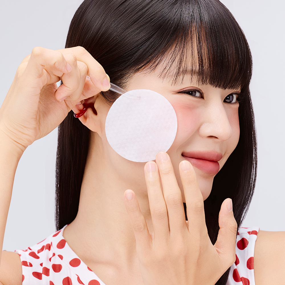 COSRX One Step Original Blemish Pore Clear Pads 100 Sheets : femme applique un pad anti-imperfections, gros plan visage en studio