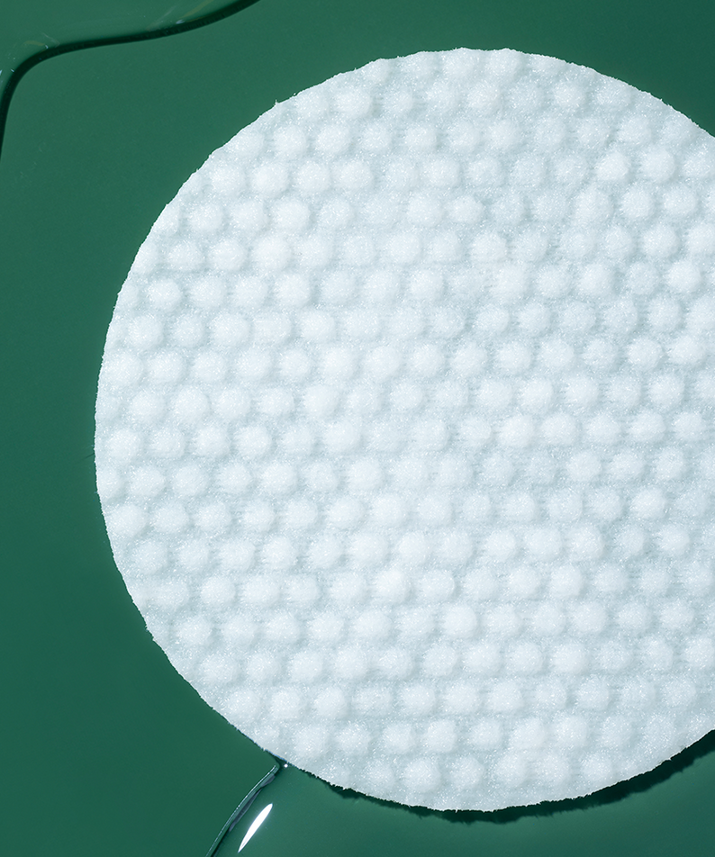 COSRX One-Step Original Clear Skin Calming Pads (100 sheets) sur coton, packs et produit COSRX en contexte vert.