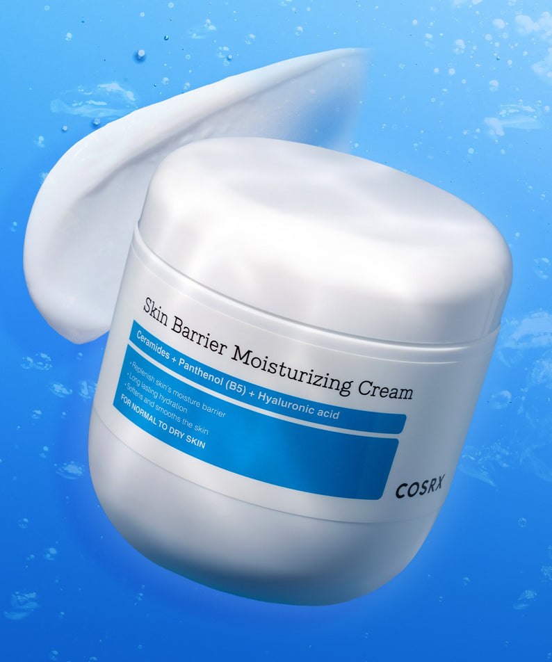 COSRX Skin Barrier Moisturizing Cream 450ml, pot blanc sur fond bleu avec gouttes d’eau, crème hydratante COSRX.