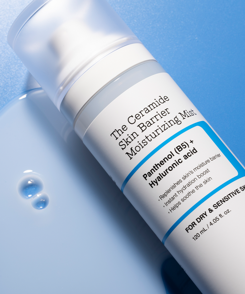 Flacon de COSRX The Ceramide Skin Barrier Moisturizing Mist 120ml sur fond bleu, écran de beauté pour peau sèche et sensible.