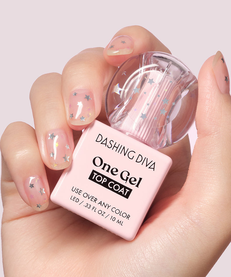 DASHING DIVA  One Gel Icy Magnetic sur ongles, bouteille en main, fond pastel, design étoiles et flocons.