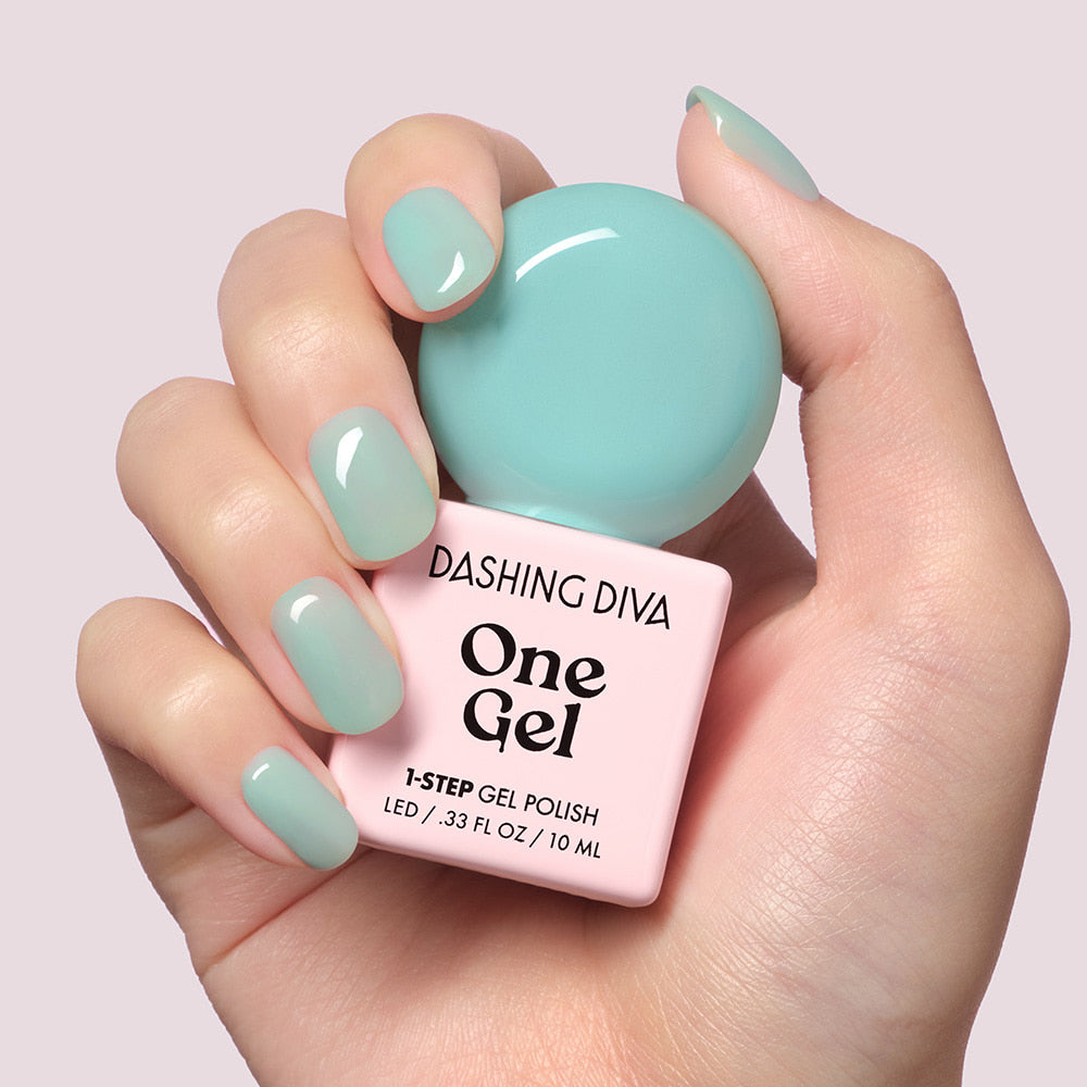 DASHING DIVA  One Gel Misty sur ongles teal, flacon et main, fond clair. Décris l'image en français.