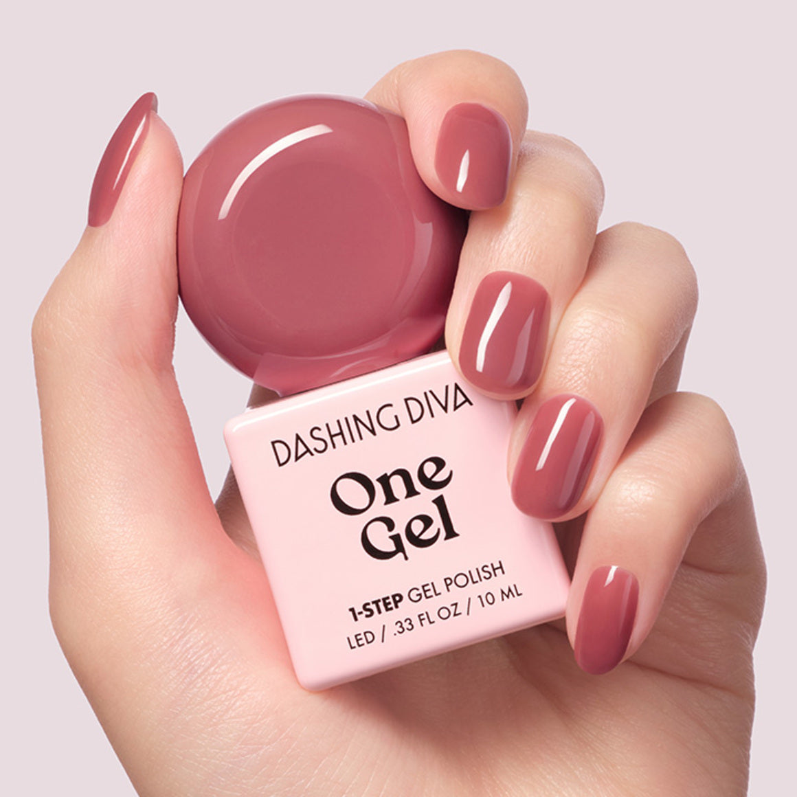 DASHING DIVA  One Gel Muted Bear, gel à ongles mauve sur mains, flacon en gros plan sur fond clair.