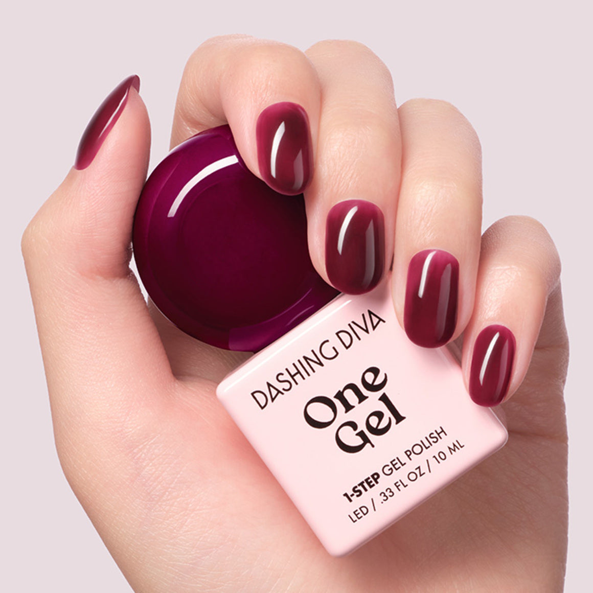 DASHING DIVA One Gel Muted Bear : vernis gel bordeaux sur ongles, flacon et étiquette sur fond clair.